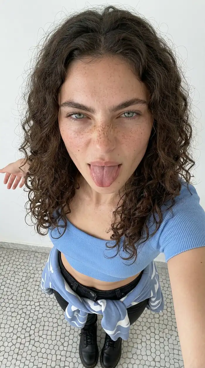 Vertical indoor selfie template featuring casual fashion and playful expression with a close-up face and upper body framing.