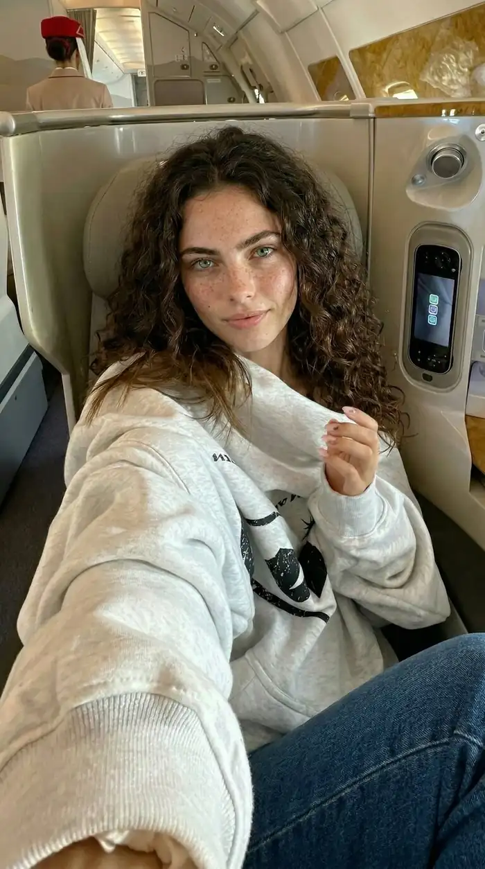 Vertical airplane cabin selfie template featuring casual lifestyle attire and premium travel interior.